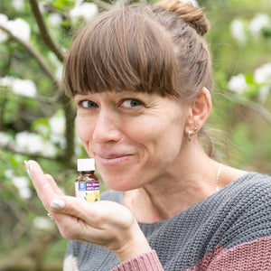 Frau mit ätherischen Zitronen-Öl in der Hand im Garten