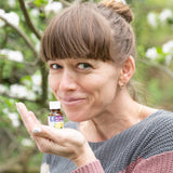 Frau mit ätherischen Zitronen-Öl in der Hand im Garten