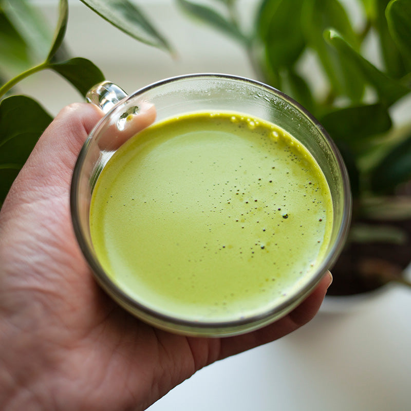 Matcha Chai Latte in Tassen und Hand