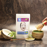 Matcha Tee mit Kokosblütenzucker mit Hand und Schale