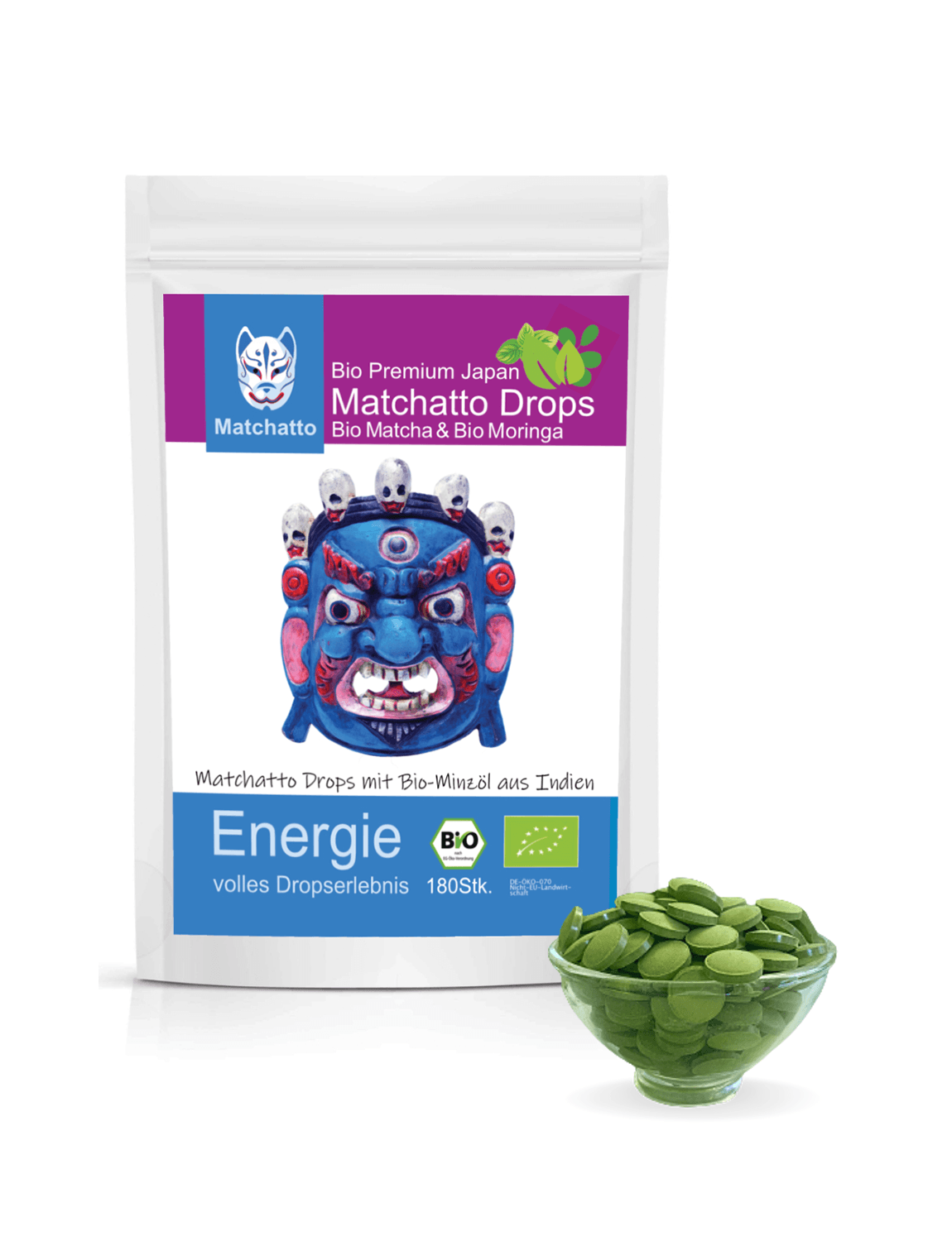 Matchatto Bio Matcha Drops mit Moringa und Minzöl aus Indien im 180er-Beutel, mit bunter Schutzgeist-Maske und Schale voller grüner Presslinge, Bio-zertifiziert.